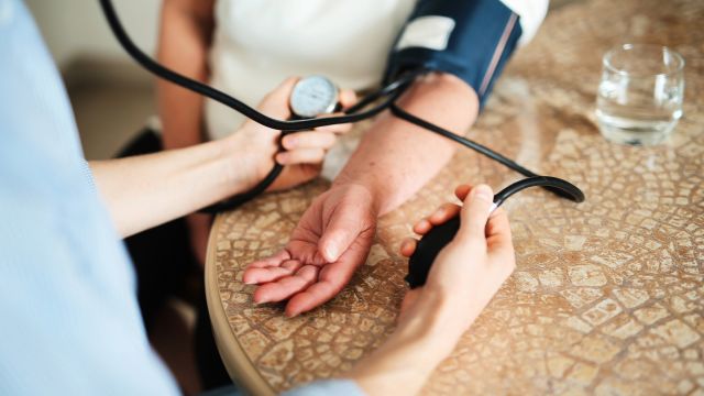 A doctor takes a blood pressure reading during an appointment with a patient who has type 2 diabetes.