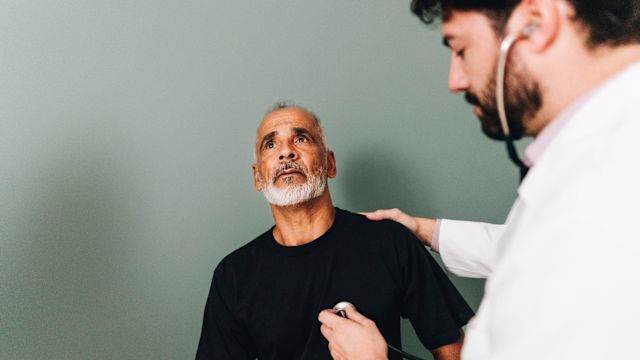 A healthcare provider listens to the heartbeat of a middle-aged male patient with a stethoscope. Depression increases the risk of cardiovascular disease, and taking steps to improve heart health are important when living with depression.