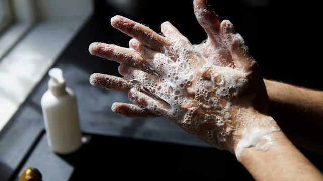 A man washes his hands with soap and water. Washing hands vigorously with soap and warm water for at least 20 seconds can help prevent illness and infection.