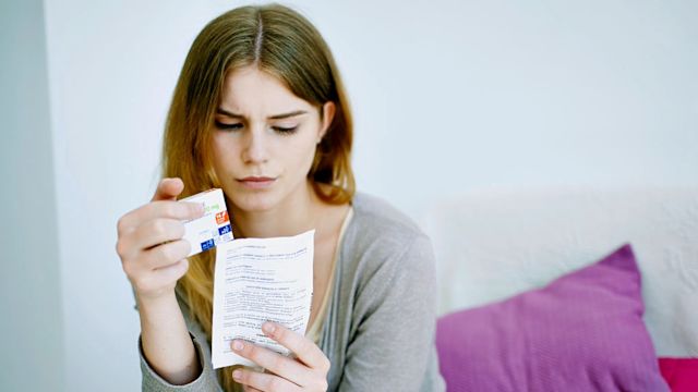 A woman read the full prescribing information for a depression medication. Understanding dosing instructions, how a medication works, and the side effects that a medication may cause are all important to improving adherence.