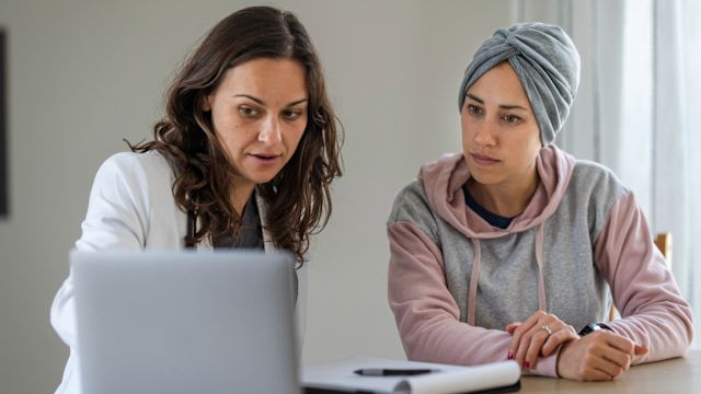 An oncologist explains the results of a diagnostic test to a woman with breast cancer.