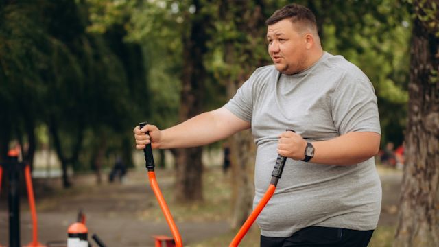 An man exercises outdoors at a park as part of a weight loss treatment program.