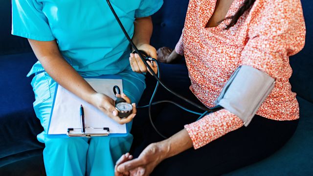 A doctor takes a blood pressure reading during an appointment with a patient who has type 2 diabetes.