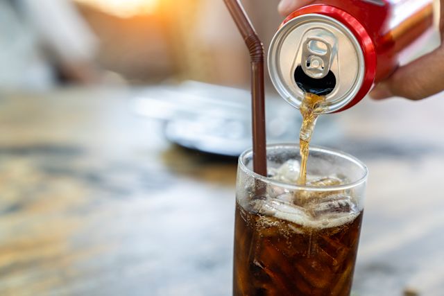 pouring soda from a can into a glass