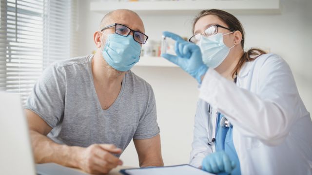 A male patient in his 60s and his healthcare provider discuss the immunotherapy drug he is about to receive with a subcutaneous injection.