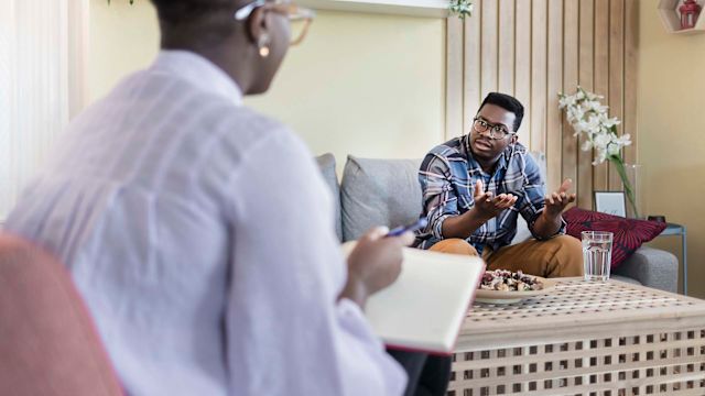 Black man speaks with doctor. 