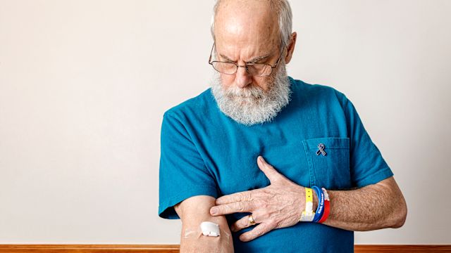 A senior man with a cotton ball bandaged to his arm after a blood test. A blood test can determine if a person can be treated with immunotherapy for metastatic uveal melanoma.