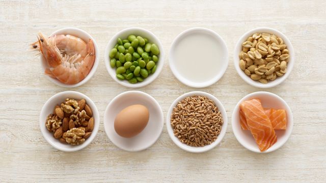 Eight small serving bowls containing eight common food allergens—shellfish, soy, milk, peanuts, nuts, eggs, sesame seeds, and fish. 