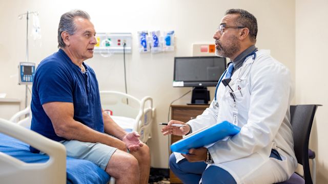 A senior-aged man and his oncologist discuss test results and treatment options for mantle cell lymphoma in a hospital room.