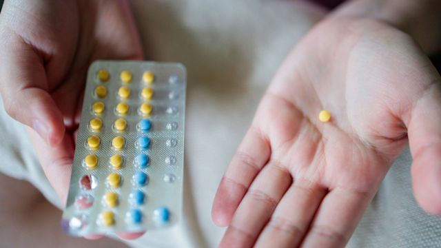 Las manos de una mujer sostienen un blíster de píldoras anticonceptivas.