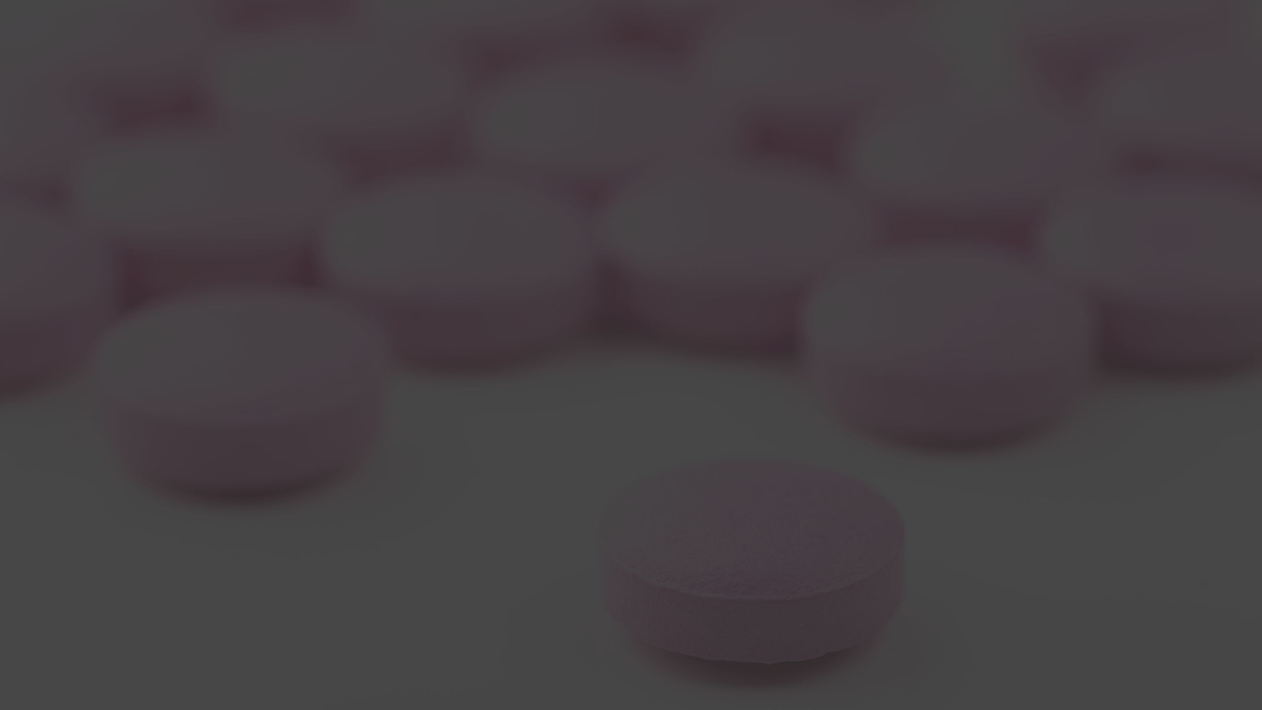 pink round pills on white background
