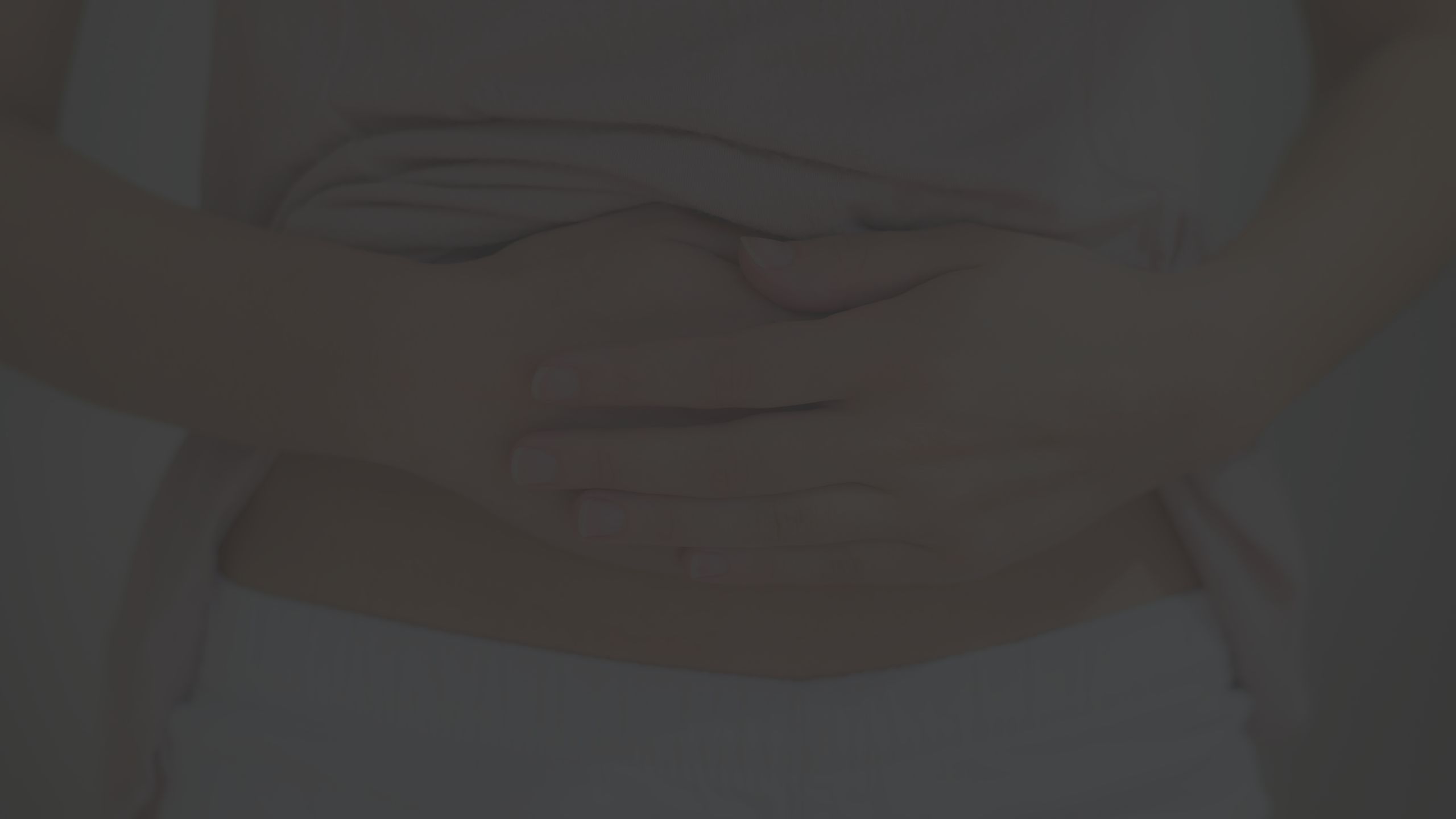 Close up shot of someone placing their hands over their lower abdomen