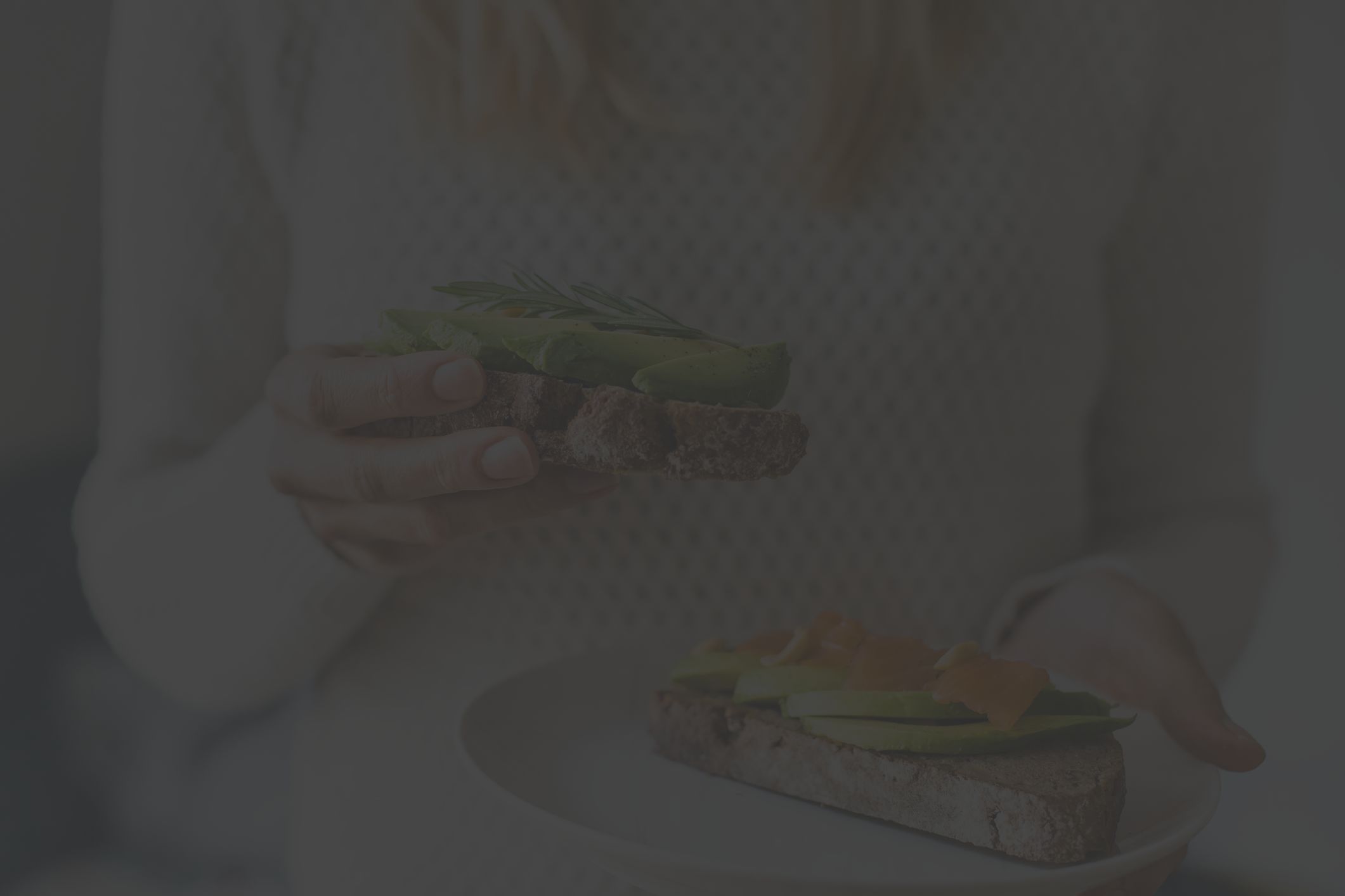 woman holding avocado toast with salmon lox