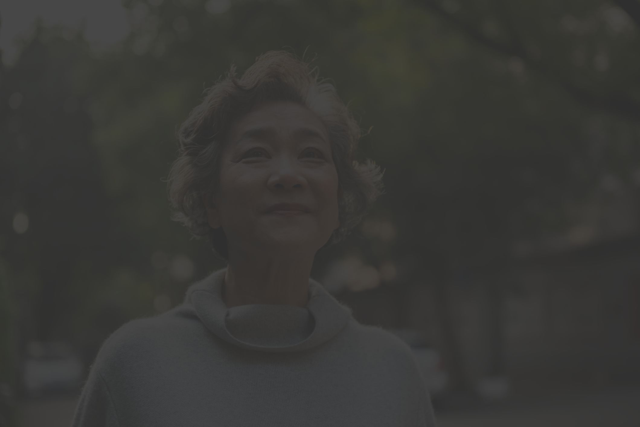 a happy, energetic middle-aged Asian American woman smiles and looks hopefully beyond the camera