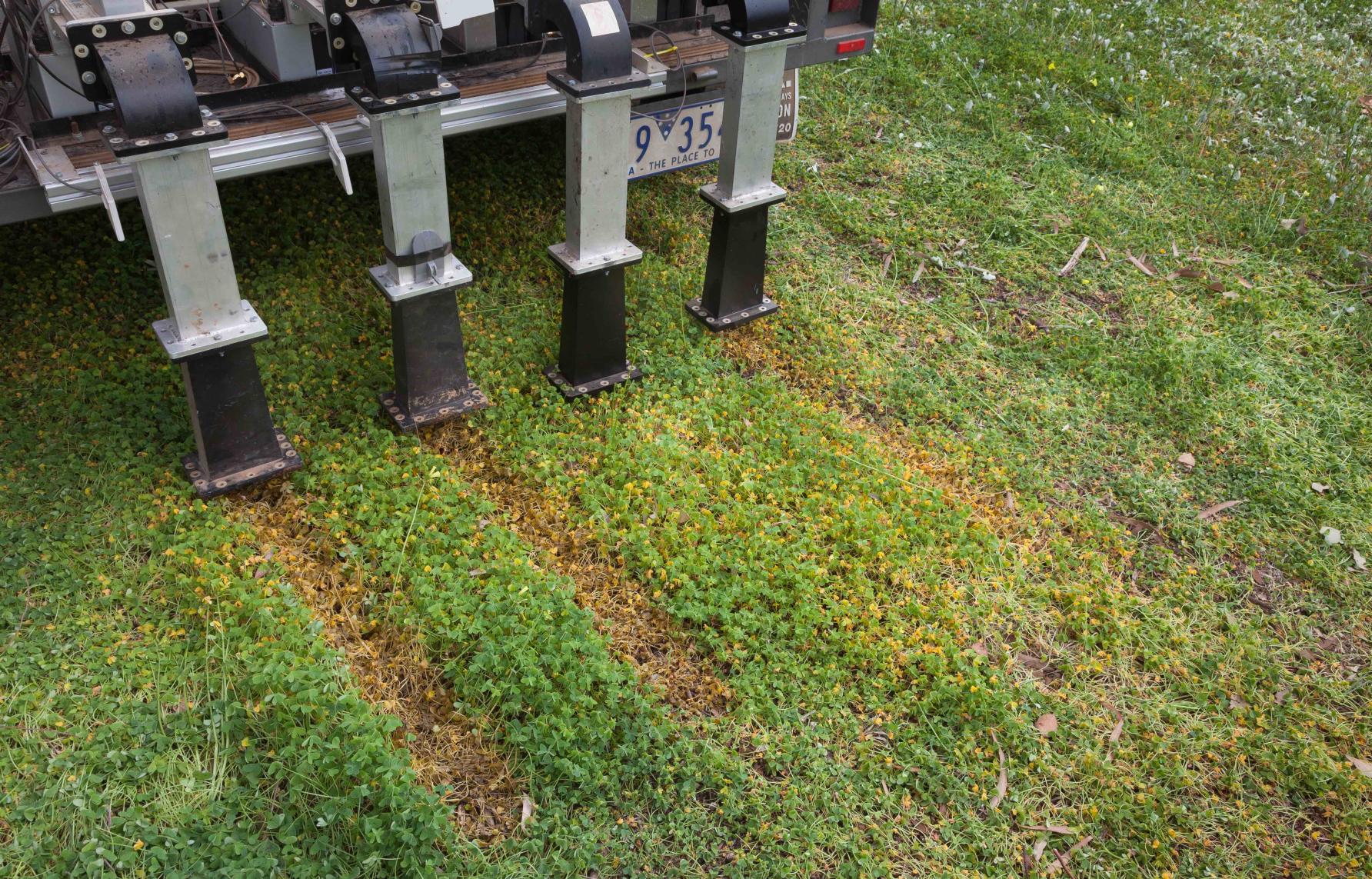 four vertical pipes on machine leave paths of dead weeds in their wake