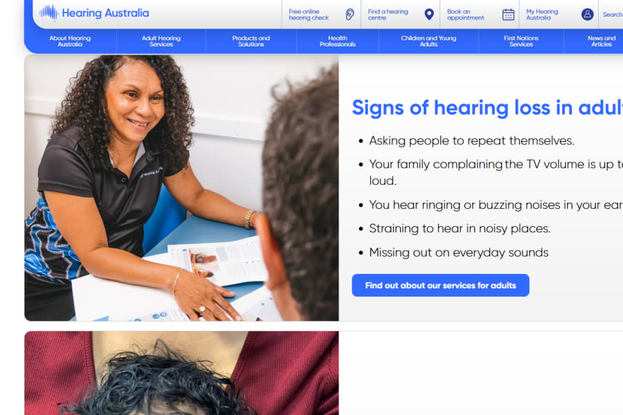 A smiling clinician showing a brochure to a patient, next to a list of signs of hearing loss in adults.